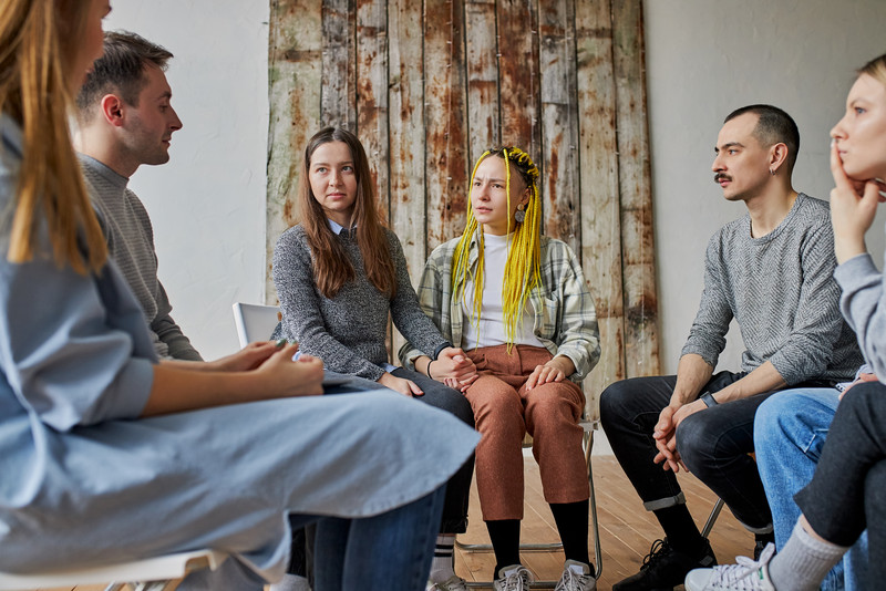 Personen sitzen im Kreis und unterhalten sich