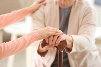 Pflegerin legt ihre Hände auf eine Patientin