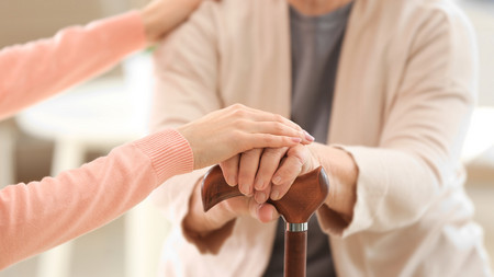 Pflegerin legt ihre Hände auf eine Patientin