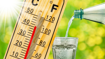 Thermoeter zeigt 40 Grad an und ein Glas Wasser