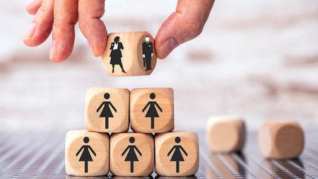 Aufgestappelte Würfel zu einer Pyramide, auf den grafisch Frauen abgebildet sind