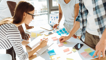 Jugendliche arbeiten an einem Tisch mit mehreren Materialien