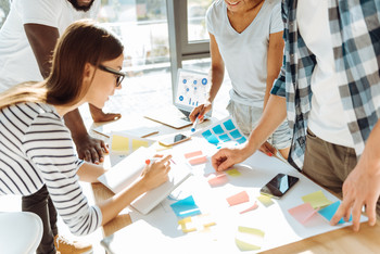 Jugendliche arbeiten an einem Tisch mit mehreren Materialien