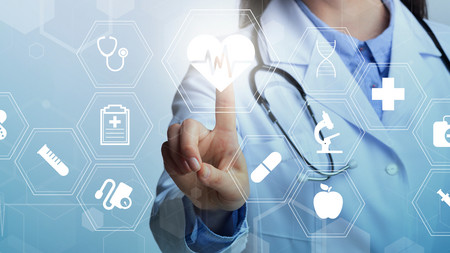Touchbildschirm mit verschiedenen Gesundheitslogos. Ein Finger berührt den Bildschirm.