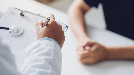 Arzt und Patient sitzen am Behandlungstisch