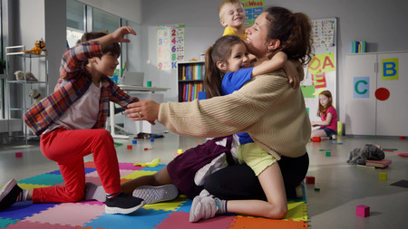 Erzieherin tobt mit Kindern im Hort