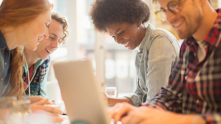 Jugendliche am Tisch sitzend, sich unterhaltend