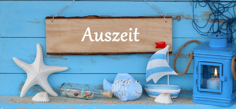 Ein Schild "Auszeit" mit ´martimer Deko