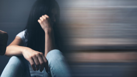 Verzweifelte Frau, auf den Boden sitzend